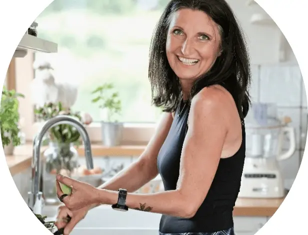 Žena v kuchyni připravuje jídlo u dřezu.