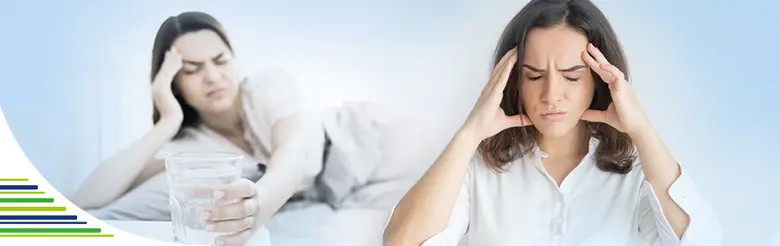 Žena trpící bolestí hlavy pije vodu na úlevu.