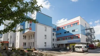 Moderní budova porodnice s modrými prvky na slunečný den.