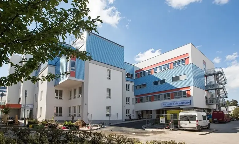 Moderní budova porodnice s modrými prvky na slunečný den.
