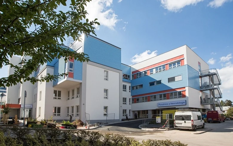 Moderní budova porodnice s modrými prvky na slunečný den.