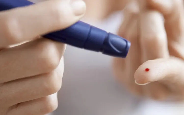 Krevní test prstem pro měření hladiny cukru v krvi.