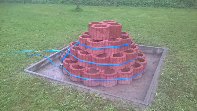 Pyramida na pěstování jahod z cihel v zahradě.