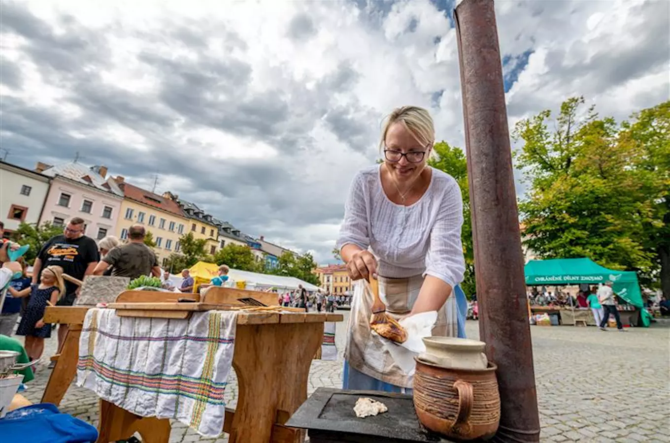 Žena mazá máslo na chlebu venku při dožínkách.