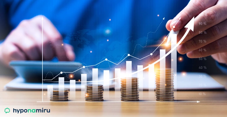 Růstající mince s grafem ukazující finanční růst a úspory.