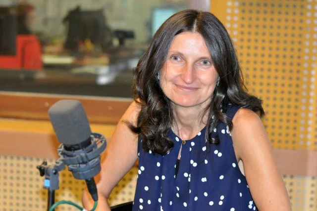 Žena s mikrofonem v rozhlasové studii.