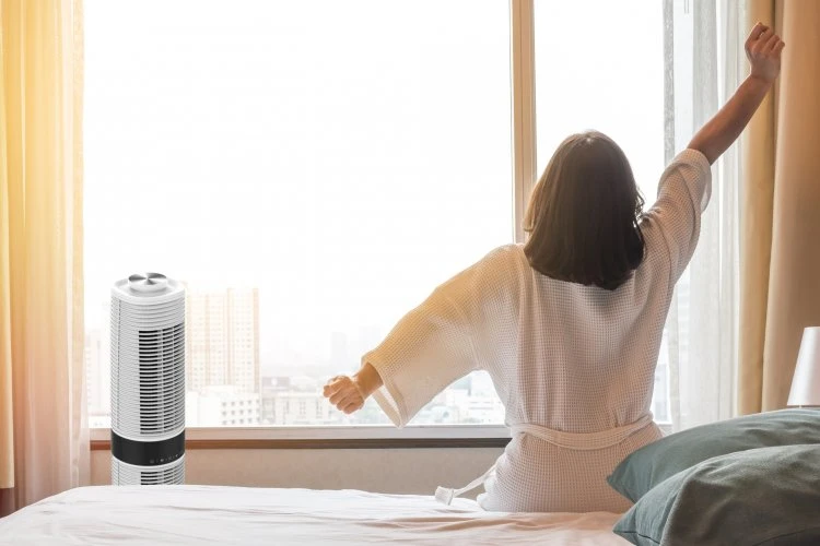 Woman stretching in bedroom with air purifier