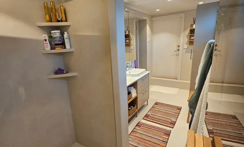 Moderní koupelna s mikrocementem v sprchovém koutu a na podlaze.